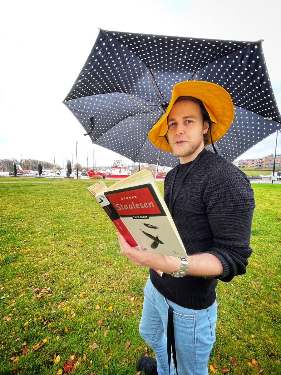 Biblioteker Thorbjørn Helin med paraply og sydvest utenfor biblioteket 